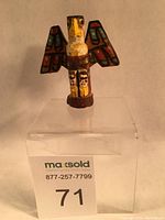Full frontal view of miniature totem eagle painted in traditional colors displayed on clear stand.