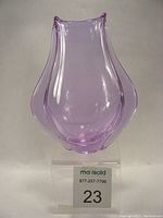 Front view of purple-pink Czech neodymium glass vase with organic shape on clear stand and lot number card visible.