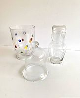 All three glass items shown together: footed millefiori vase, glass dome, and nested carafe with tumbler lid.
