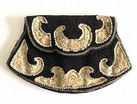 Front view of antique ladies clutch showing black beadwork and embroidered floral panels with pearl-mimicking larger beads