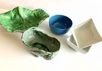 Five ceramic pieces including large green cabbage leaf bowl, vintage planter, blue cereal bowl and two white rice bowls set on white background