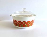 Front view of the vintage Pyrex casserole showing the colorful mod pattern and overall shape with glass lid.