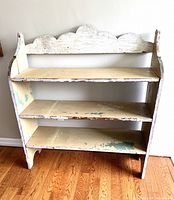 Front view of the three-shelf primitive pail bench showing distressed paint and scalloped back panel.