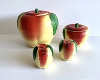Front angle view of 4-piece vintage McCoy yellow apple kitchen set: cookie jar, grease jar, salt and pepper shakers.