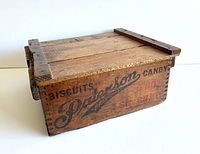 Wooden egg crate with printed text 'Patterson Biscuit & Candy Company, Brantford' on sides, closed with lid, showing craftsmanship and patina.