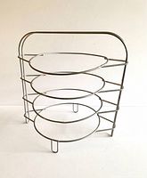 Front view of vintage wire pie or plate rack showing four circular plate holders and chrome finish