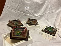 Four baseball stadium replica models placed on white fabric background with their original white foam packaging.