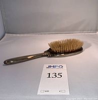 Side view of the antique silver hair brush showing handle and bristles
