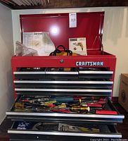 Front view of red Craftsman chest with lid open and one drawer extended showing screwdrivers