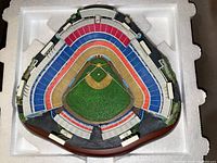 Top view of detailed Dodger Stadium model with colored seating sections and green field inside protective foam packaging.