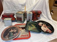 Overall lot showing 13 plaid hinged tins and four metal trays with vintage Coca-Cola and Pepsi advertising artwork