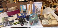 Wide view of various boxed and unboxed model kits including Space Needle, Montreal Olympic Stadium, Metal Works Eiffel Tower and Washington Monument, Golden Gate Bridge, and assorted parts in plastic bag and box