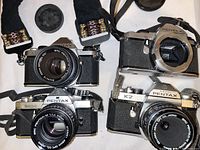 Overview of four camera bodies, lenses and focusing screens on white background