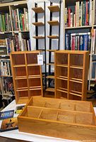 Three solid wood vertical CD storage racks with bookshelves in background, showing natural wood color and Napa Valley branding