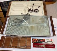 Photo showing two vintage warming trays stacked with wooden handles visible, a Danish teak serving tray with three glass holders, and boxed poultry shears