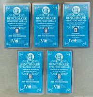 Five sealed pieces of 0.25 grain .999 fine platinum bullion with certificates of authenticity from Benchmark Strategic Metals showing Liberty head logo and certification details.