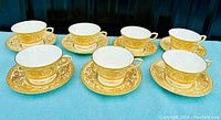 Seven Royal Worcester Embassy pattern tea cups and matching saucers set on a blue cloth background showing overall lot contents.