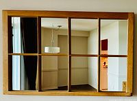 Front view of rectangular antique wooden window frame mirror with eight mirrored panes.