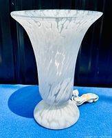 White and clear art glass urn-shaped torchiere table lamp with mottled pattern visible, shown on a blue background with power cord visible.