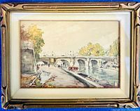 Full view of framed original painting featuring a river with stone bridge and walkway under glass in ornate golden frame.