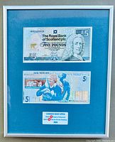 Framed pair of £5 banknotes under glass showing the front of the notes with the Jack Nicklaus commemorative and standard Royal Bank Scotland note.