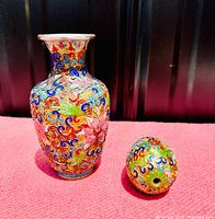 Photo of the cloisonné vase and egg on a pink fabric background, showing front and side views of the vase and the egg's top hole.