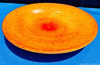 Top view of a vintage swirled orange Murano blown glass bowl showing color and shape.