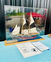 Overall lot view: model under acrylic dome on wooden base with paperwork in front