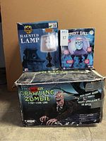 Boxes of the Haunted Lamp, Spirit Ball, and life-size Crawling Zombie animatronics grouped together