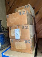 Four stacked cardboard boxes each labeled 12 jars 16 oz, showing used condition.