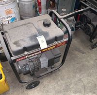 Full view of the Coleman Powermate Maxa 3000 OVH generator showing frame, fuel tank, wheels and engine area.