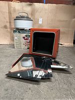 Image shows the Open Country digital dehydrator, its box, and a solar oven with reflective panels separated and outer orange shell visible.