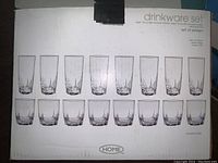 Closed white box labeled 'drinkware set' showing a set of sixteen tall and short drinking glasses, representing a set of wine glasses and tumblers.