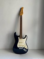 Front full body image of the Jay Turser Stratocaster style electric guitar with blue finish and white pickguard.
