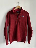 Full front view of the red Patagonia sweater showing zip-up style and chest pocket zipper.