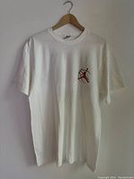 White vintage Nike Air Jordan T-shirt hanging on wooden hanger against plain wall