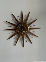 Front view showing full starburst design with teak rays and brass accents