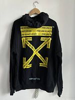 Rear view showing large yellow caution tape arrow motif and TEMPERATURE text