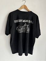 Rear view of the black Harley-Davidson t-shirt showing the 'GOOD GUYS WEAR BLACK' text above an illustrated motorcycle graphic.