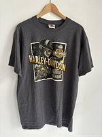 Front view of a large grey Harley-Davidson T-shirt showing front design with helmet graphic and Harley-Davidson branding.