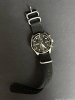Full view of the Fossil men's chronograph watch with black nylon strap laid flat.