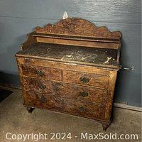 Front view of the antique pine dresser with hand painted burl walnut wood grain finish showing wear on the top surface and ornate drawer handles.