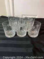 Front view of eight crystal glasses arranged in two rows showing the pinwheel cut pattern.