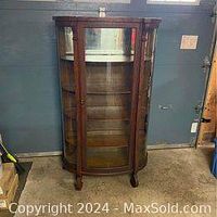 Front view of antique wooden display cabinet with curved glass door