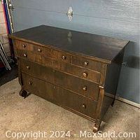 Solid wood vintage dresser with 6 drawers and metal wheels, dark wood finish, photographed at angle showing side and front