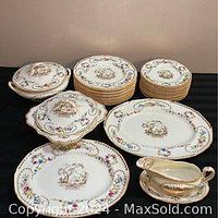 Overall view of dinner plates, lunch plates, dessert plates, covered serving dishes, gravy boat with tray and platters arranged on table.