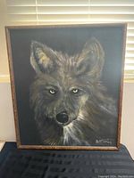Front view of the original wolf painting in brown wooden frame, signed B. McCarter at lower right.