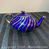 Angled side photo of the cobalt blue and white striped teapot, showing spout and handle.