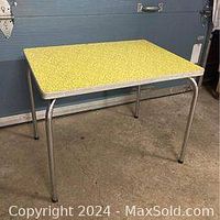 Full view of yellow melamine side table showing aluminum edge and metal legs.