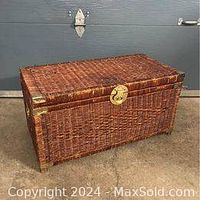 Full view of the vintage wicker rattan blanket box chest showing front and top, highlighting brass latch and woven texture.